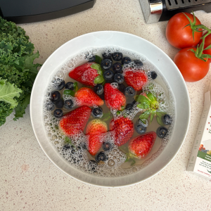 Fruits being washed in bowl of water