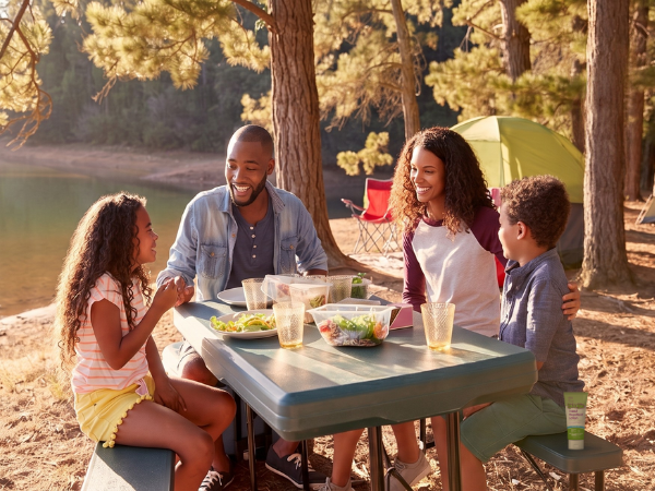 a family having lunch outside at their campsites