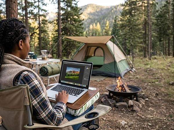 woman at a camp site using a lap desk to work remotely