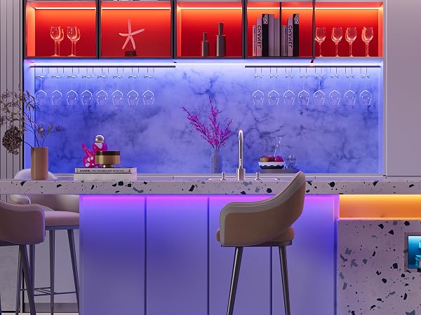 Modern bar setup with illuminated red shelves, blue backlit wall, and purple counter. Features wine glasses, bottles, and bar stools in a stylish, contemporary design.