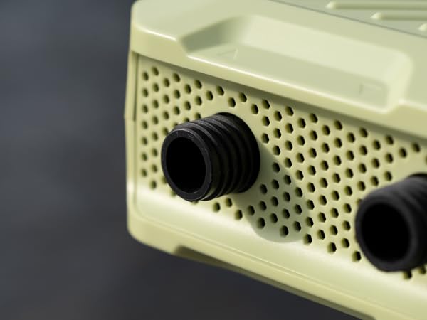 Close-up of a beige electronic device with perforated front panel and two black knobs, possibly a vintage radio or speaker.