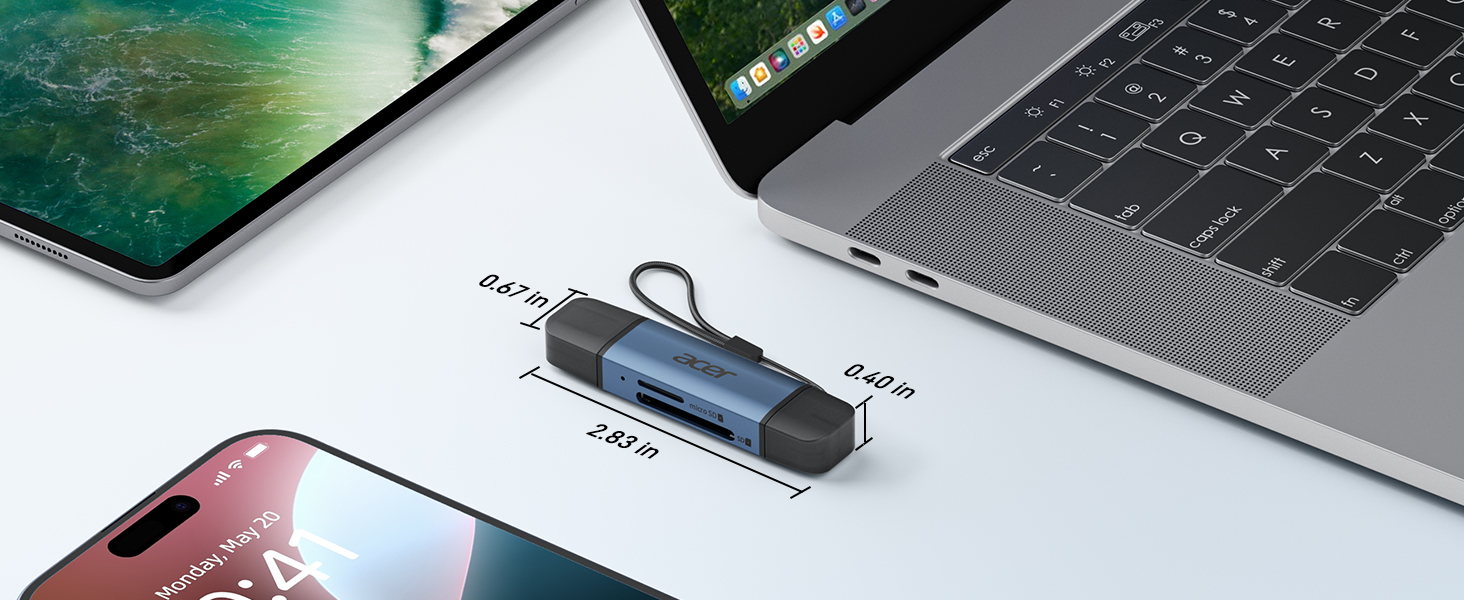 USB hub or adapter connected between MacBook laptop and mobile devices on desk surface, showing multiple connection ports.