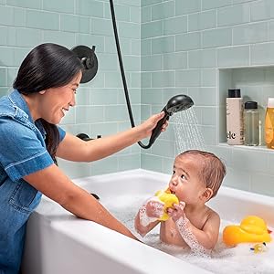Image of a mother washing her baby with a handheld shower