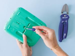 Open It Tool unscrewing a battery compartment on a toy