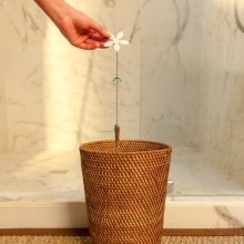 Hand throwing away the used DrainWig with hairball attached into the trash