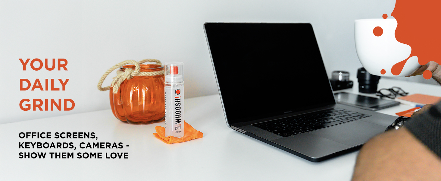 WHOOSH! screen cleaner bottle and microfiber cloth next to a MacBook Pro laptop.