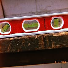 the same torpedo Level rests on an old wood log showing durability