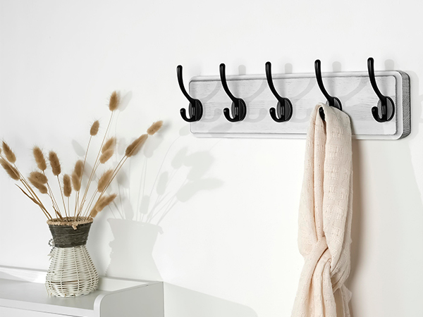 There is a weathered white wall-mounted coat rack at the entrance to the warehouse
