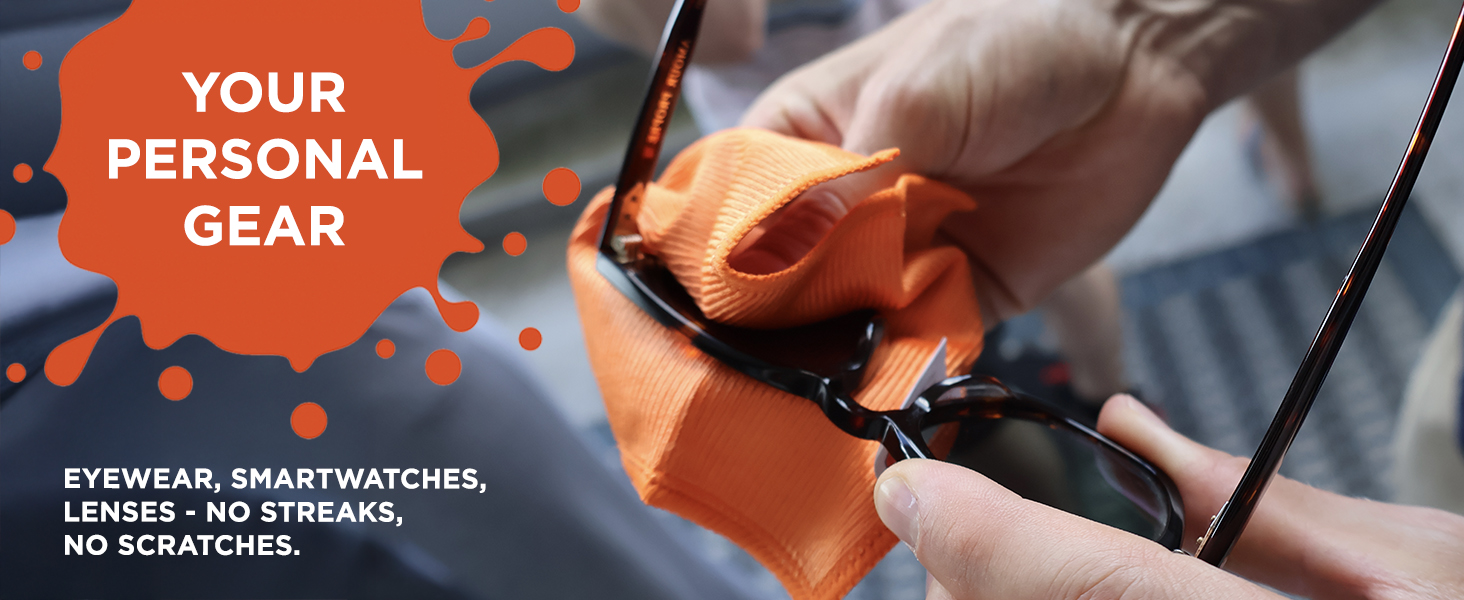 Close-up of hands polishing sunglasses with an orange microfiber cloth, ensuring a streak-free clean