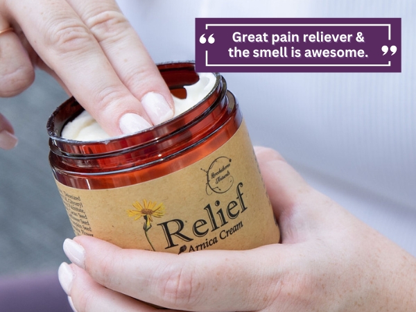 Relief arnica cream being applied to sore muscles.