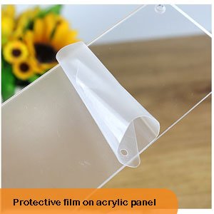 Clear protective film being peeled from an acrylic panel surface, with sunflowers visible in background.