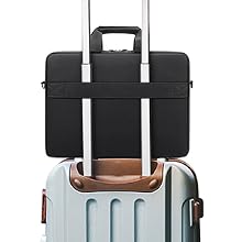 Black laptop bag with handles and strap, positioned on top of light gray hardside rolling suitcase with extendable handle.