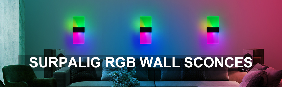 Three colorful RGB wall sconces emitting vibrant hues of green, blue, and pink light, mounted on a wall above a couch in a dimly lit room.