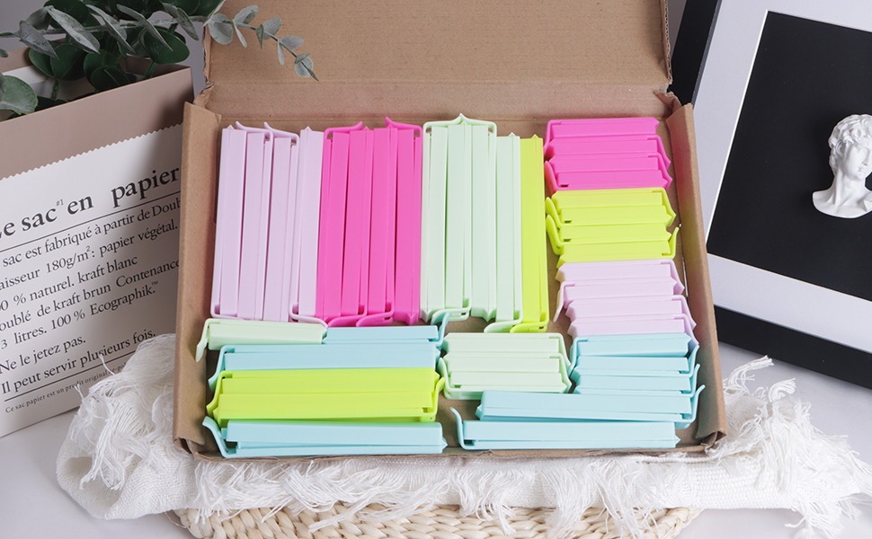 Box filled with colorful plastic book tabs or page markers. Various pastel shades including pink, green, yellow, and blue organized in rows.