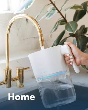 Hand holding and filling a LARQ Pitcher over a kitchen sink