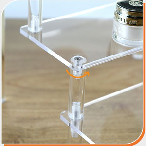 Close-up of clear acrylic or plastic mounting hardware, featuring transparent cylindrical connectors and flat panels joined at right angles.