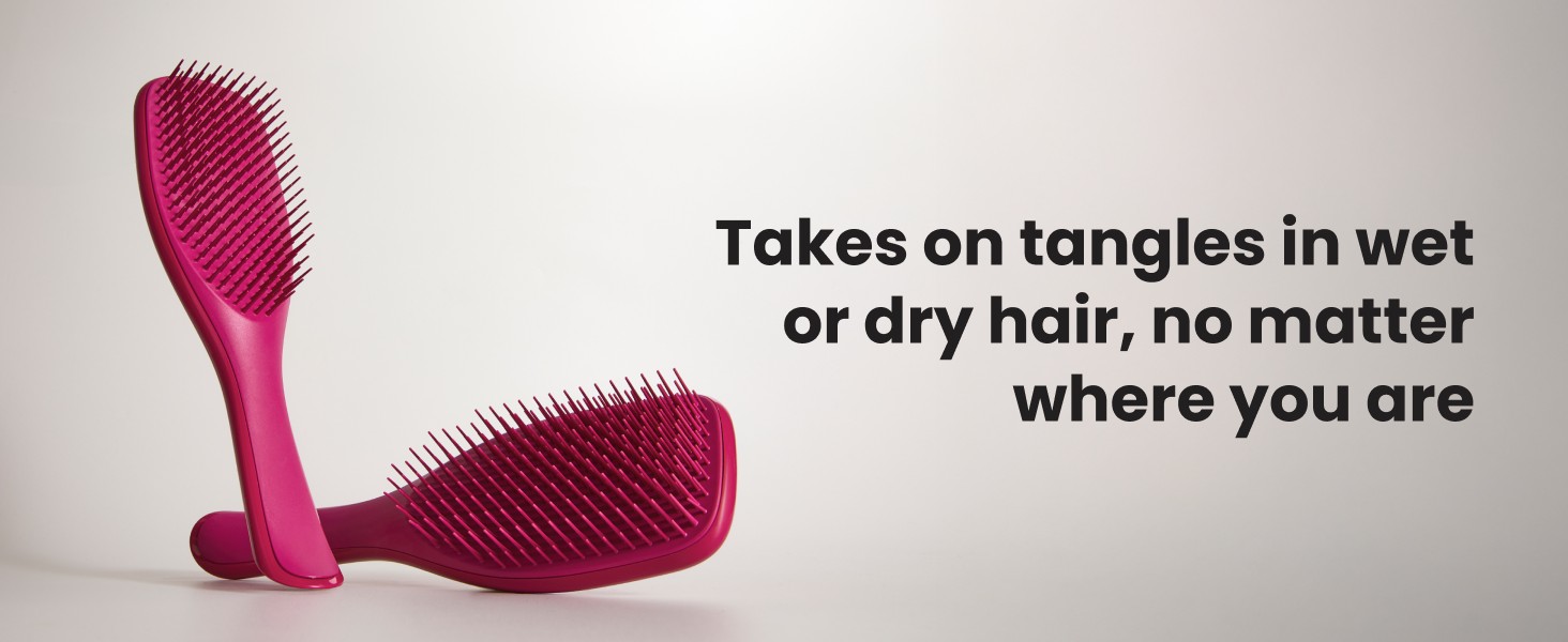 Two pink ultimate detangler brushes on top of a surface.