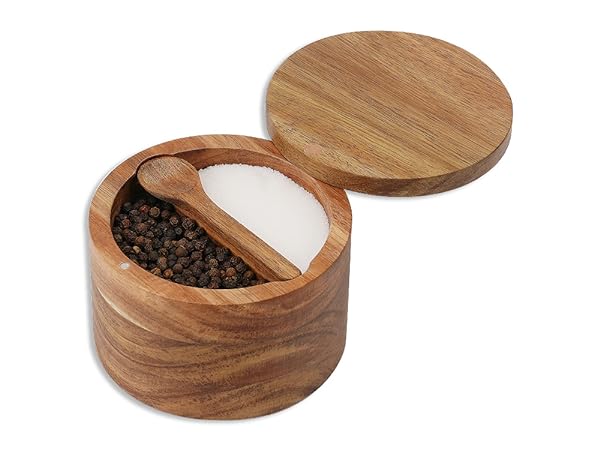 Wooden circular container with two compartments. One side contains dark spices, the other white salt or sugar.