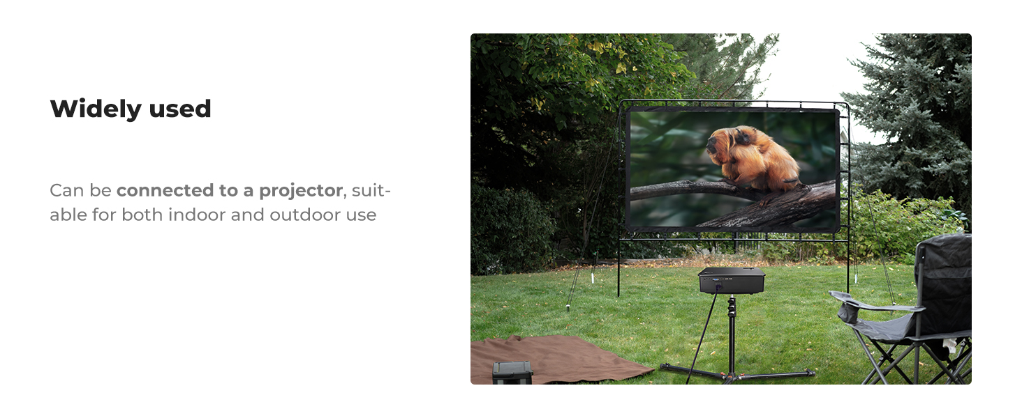 Portable outdoor projector screen set up on a lawn, displaying an image of a dog. A projector and folding chair are visible nearby.