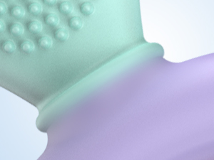 Close-up of a textured mint green silicone object with raised bumps, partially visible against a lavender background. The object's full shape and purpose are unclear.
