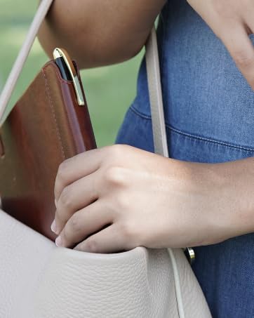 Close-up of a white handbag with leather trim, showing detail of the bag's structure and hardware.