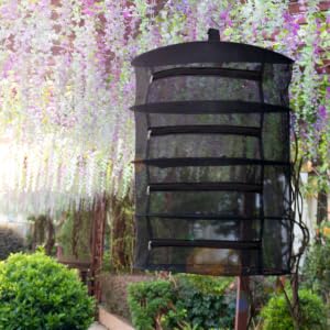 Text reads 'Image 1'. Series of hanging metal or dark-colored lanterns with horizontal slats arranged in a garden setting with flowering vines and foliage in background.
