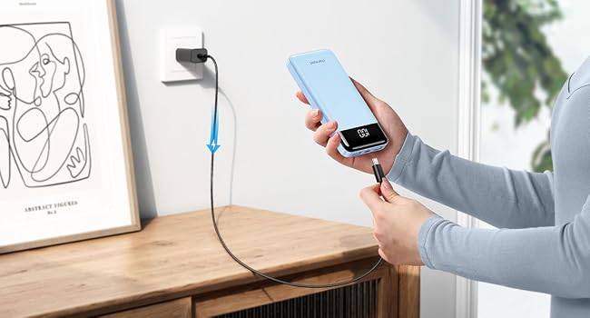 Wireless charging setup on desk with line art print, showing phone being charged and wall-mounted charging device.