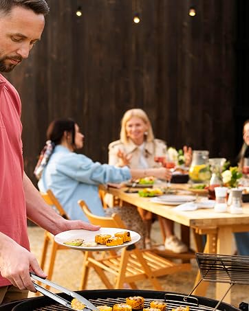a man serving food to a group of people at a table.