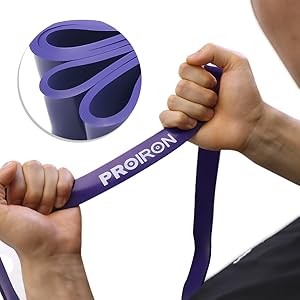 Purple fitness resistance band shown being stretched and demonstrated in multiple positions, highlighting its elasticity and various exercise applications.