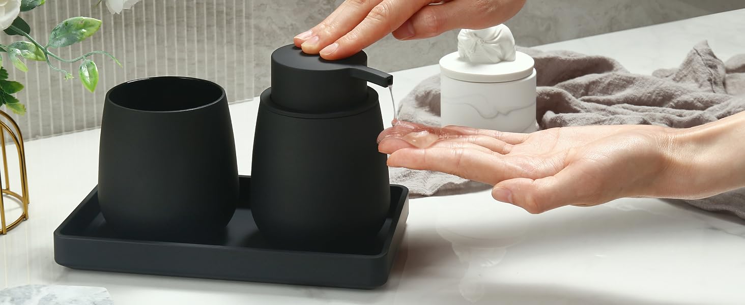 Bathroom set with black ceramic soap dispenser and matching container on a black tray. Hands demonstrate dispensing soap into palm.