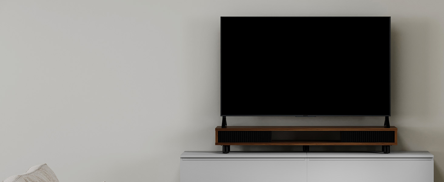 Wall-mounted flat-screen television above a sleek, modern media console or shelf. Minimalist design in a neutral-toned room setting.