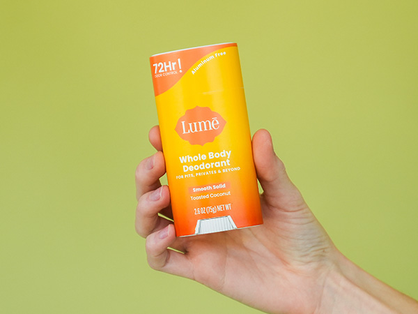 Lume Solid Stick Deodorant in Toasted Coconut being handheld