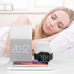 a woman is sleeping in her bed with a smart phone and a clock.