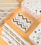 Assortment of patterned tissue boxes on orange background. Designs include stripes, polka dots, chevrons, and stars in white, gold, and silver colors.
