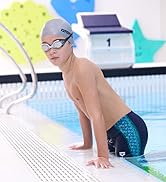 boy wearing silver arena swim cap arena swim goggles and arena swim jammers in an indoor pool