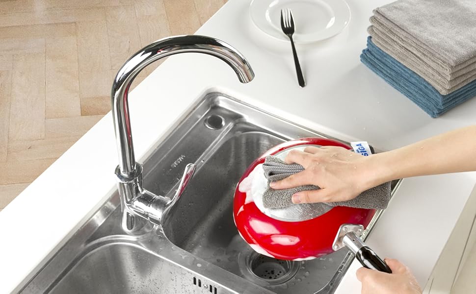 a person washing a dish in a sink.
