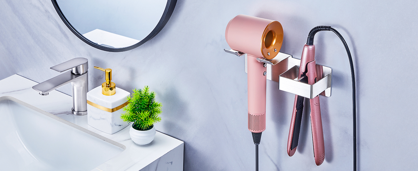 Text reads 'Image 1'. Wall-mounted bathroom organizer in rose gold finish holding hair dryer and styling tools, installed next to white sink with green plant decoration.