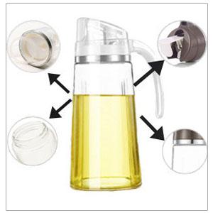 Glass oil dispenser with yellow liquid inside. Features detachable parts including clear and opaque lids, pouring spout, and handle. Arrows point to removable components.
