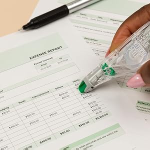Correction tape being used to edit a printed expense report
