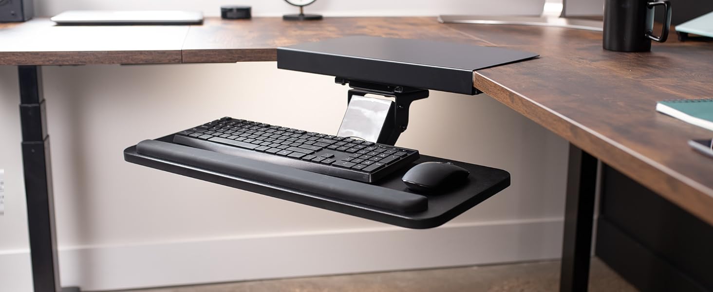 Black keyboard tray extended from corner desk