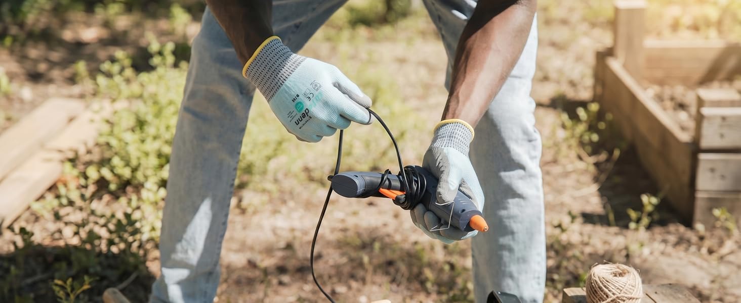 Worker handling a power tool outdoors wearing Safedenn cooling work gloves for heat relief.