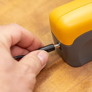 pocket knife being sharpening in handheld electric knife sharpener electric plug in