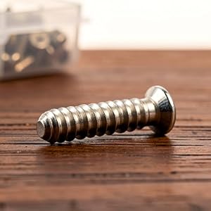 Silver flat head Phillips screw for laptop repair.