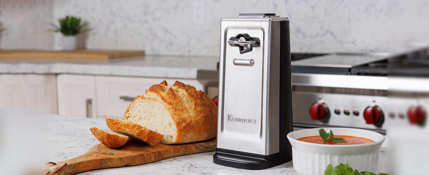 Kenmore smooth-edge can opener on a white marble countertop with a loaf of bread and bowl of soup
