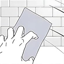 Illustration of a hand using a rectangular tool to apply grout between white tiles on a wall.