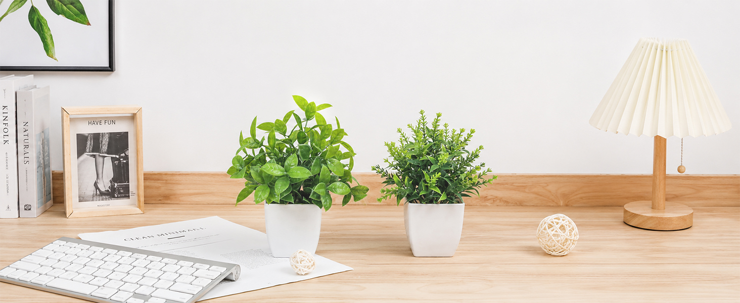 two artificial green plants white pots office desk decor