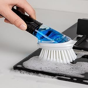 a person cleaning a brush with a blue toothbrush.