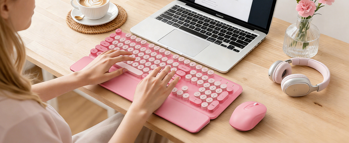 Person using a Blush Pink round-keycap wireless keyboard with wrist rest and matching mouse