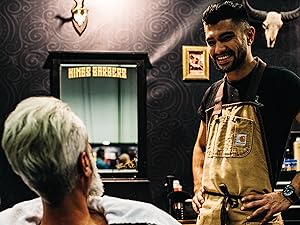 a man in a barbershop talking to a customer