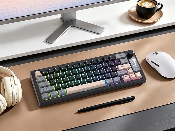 Mechanical keyboard with black and gray keys and green accents, white mouse, headphones, coffee cup, and monitor on wood desk workspace setup.